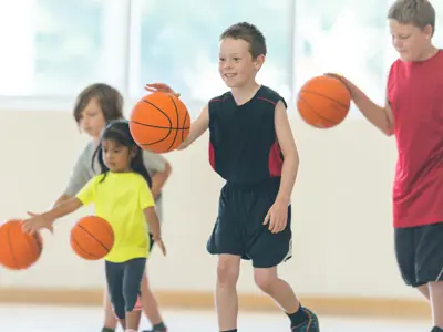 kids with basketballs learning how to play