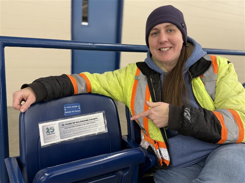 Haldimand staff member sitting at an arena chair pointing to a Silver Ticket