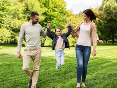 Parents lifting a child between them holding one arm each