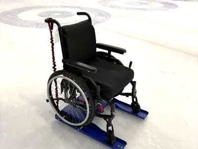 Wheelchair on ice rink with accessible skating aid attached