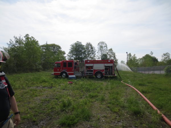 A firetruck pumps water to a burning building